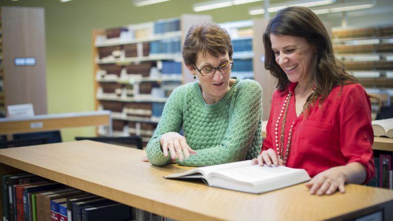 women reading book in law library